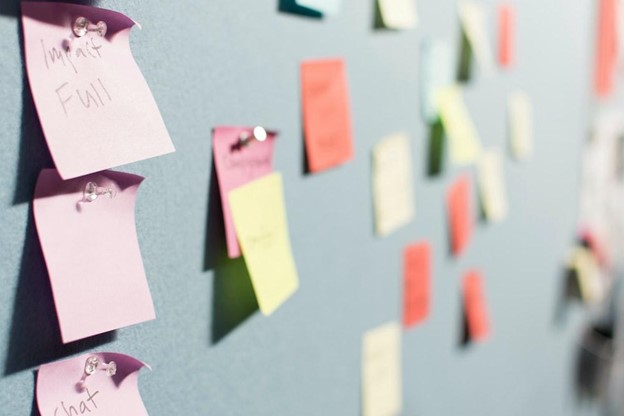 a notice board full of notes to show preparing to switch to a digital asset management software